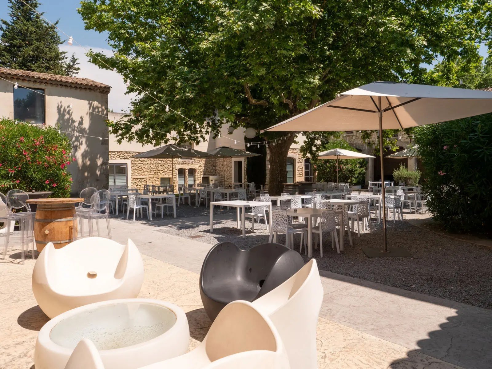 La cour ombragée, ses tables et ses parasols