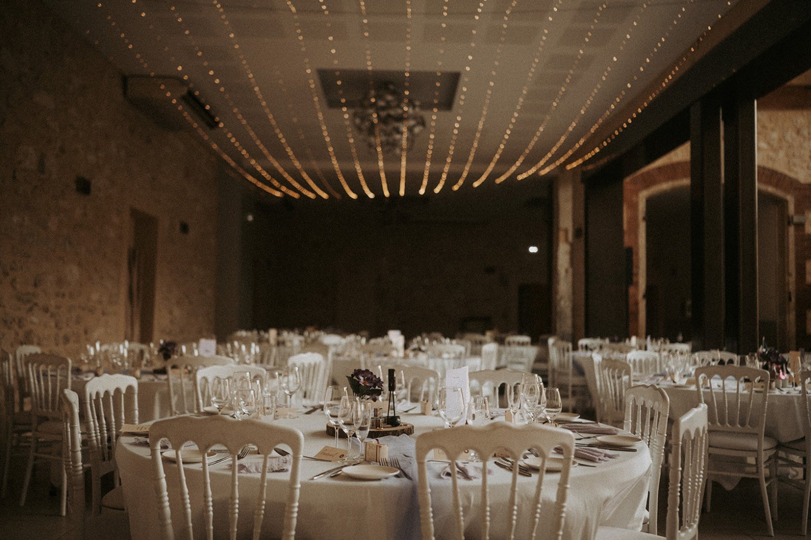 La salle illuminée de guirlandes pour le dîner